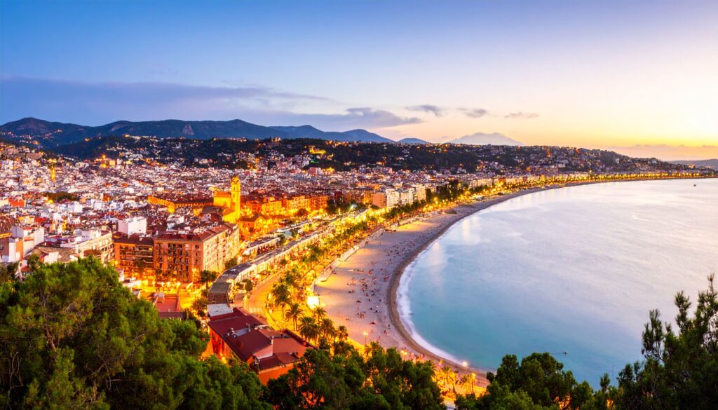 Spanien Reiseblog: Panorama einer abendlichen Küstenstadt mit beleuchteter Promenade und gestaffelten Vierteln